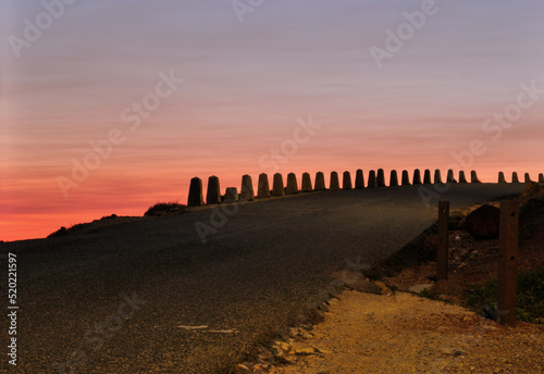 Estrada antiga de montanha com mecos em pedra, nascer do sol no horizonte photo