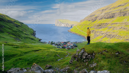 Man silhouette on background of famous Risin og Kellingin rocks and Tjornuvik village, of Eysturoy, Faroe Islands, Denmark. Landscape photography. Travel lifestyle concept hiking adventure. photo