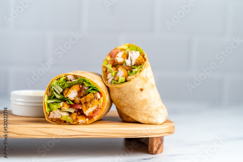 Fried chicken wrap on wood serving plate photo