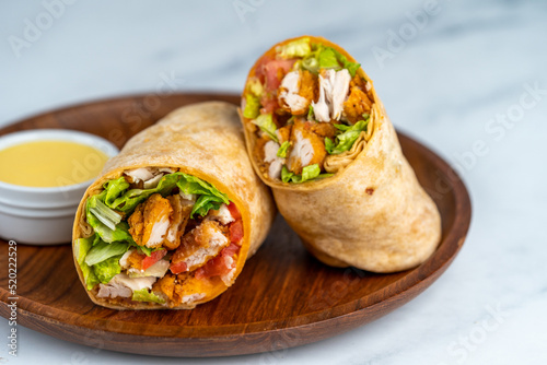 Fried chicken wrap on wood serving plate photo