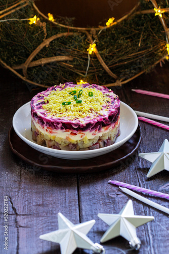 Dressed herring, raditional Soviet festive salad of herring and vegetables in a New Year's decoration.