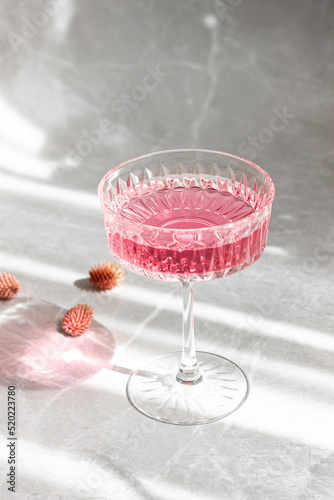 pink cocktail in glass on marble table