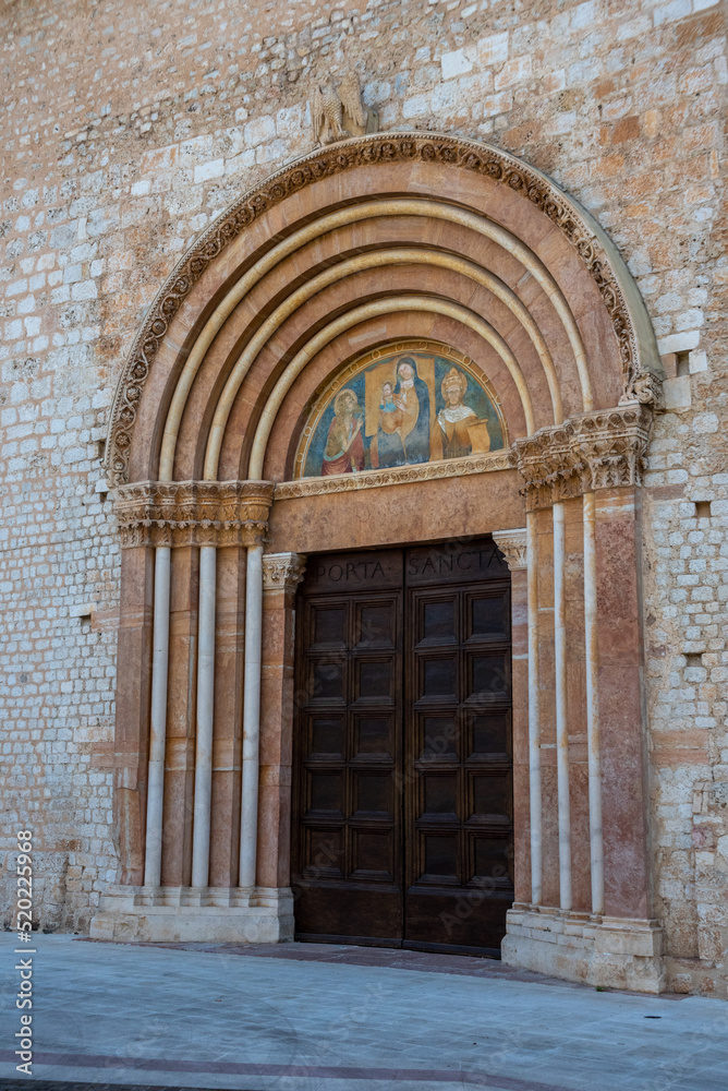 Ornate side door of the rebuilt Romanesque basilica di Santa Maria di Collemaggio in L'Aquila, Italy