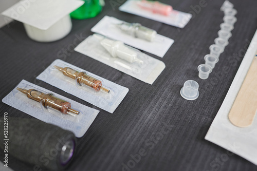 Tattoo studio scene. Set of different sterilized needles on the work table of a tattoo artist to use in a design tattooed on the skin.