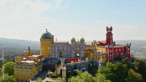 High aerial view Pena palace portuguese heritage of unesco stronghold historic european residence catholic fortress with yellow red decorative facade mansion on summit rocky hilltop in Sintra Portugal photo