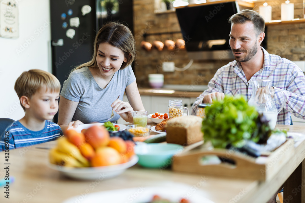 Young happy family enjoying in their brekfast time in dining room