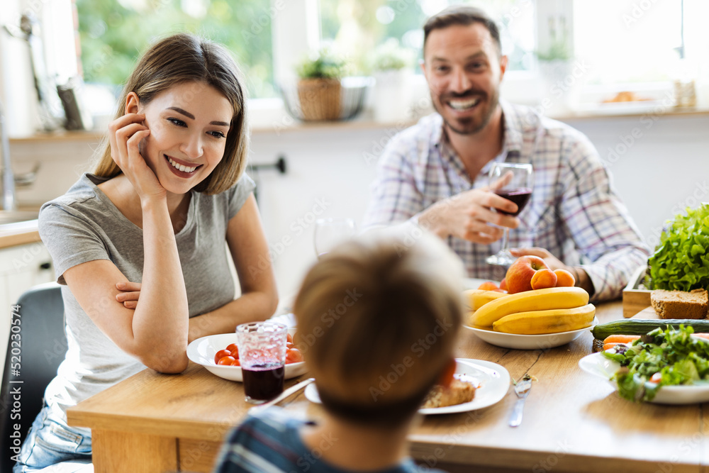 Young happy family enjoying in their lunch time in dining room Young happy family enjoying in their lunch time in dining room