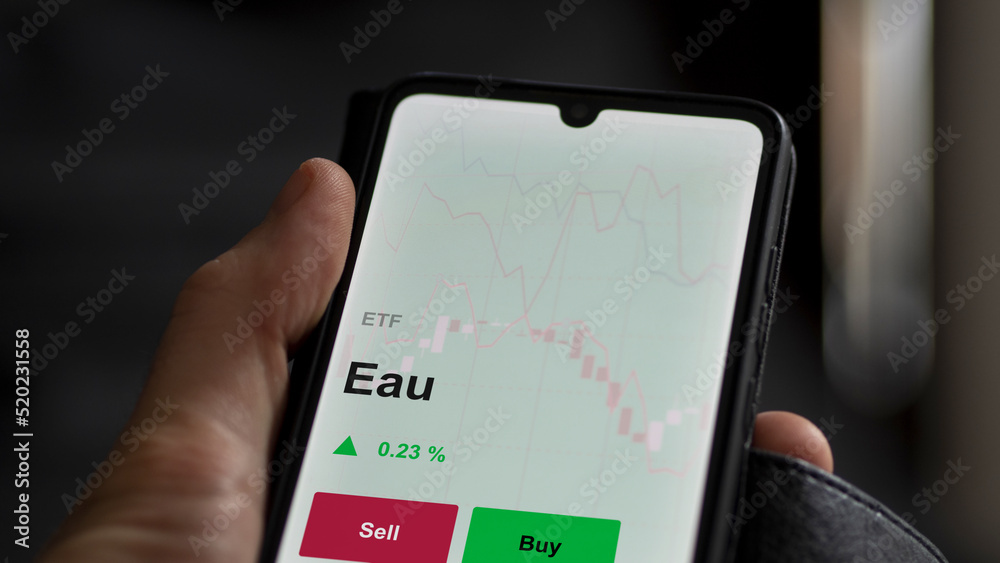 Un investisseur analyse un fonds etf eau sur un graphique. Un téléphone affiche le cours de l'ETF Eau Un investisseur analyse un fonds etf eau sur un graphique. Un téléphone affiche le cours de l'ETF Eau