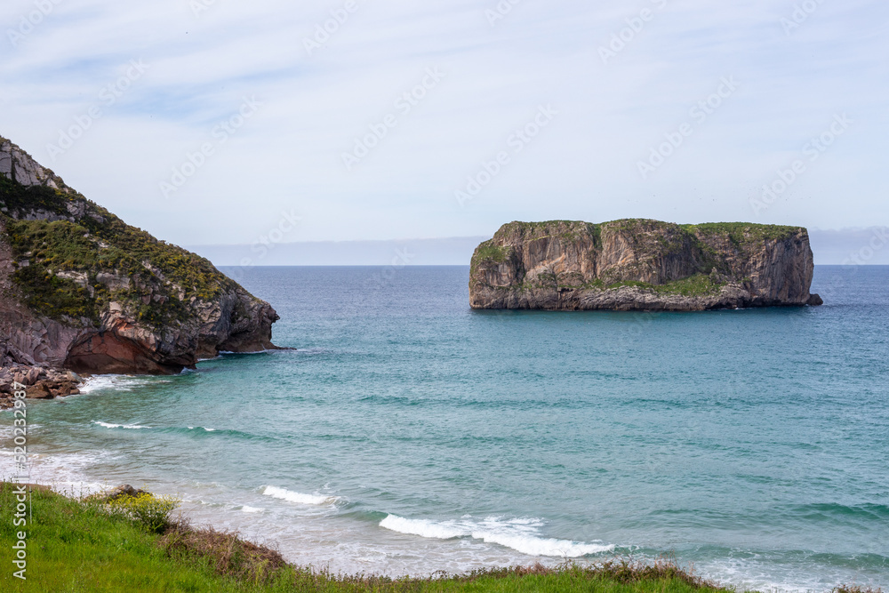 Northern Spain beach, beautiful sea, next to cliffs and rocks on the shore