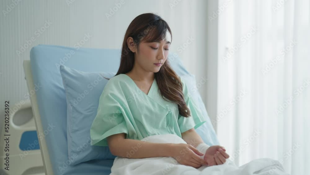 Sad female patient sitting in hospital bed. She was sad about her injuries. Insurance, Healthcare, Lifestyle, Sadness, Hospital, Hope concept. Sad female patient sitting in hospital bed. She was sad about her injuries. Insurance, Healthcare, Lifestyle, Sadness, Hospital, Hope concept.