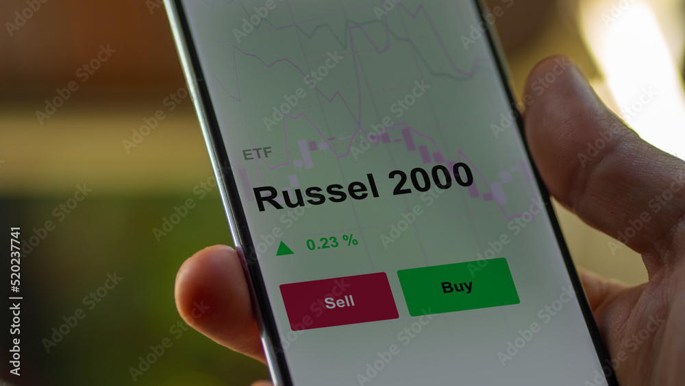 Un investisseur analyse un fonds etf russel 2000 sur un graphique. Un téléphone affiche le cours de l'ETF. Texte en français francais Russel 2000 Un investisseur analyse un fonds etf russel 2000 sur un graphique. Un téléphone affiche le cours de l'ETF. Texte en français francais Russel 2000