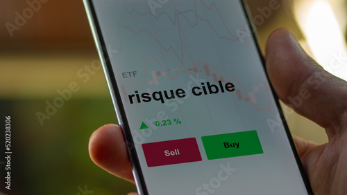 Un investisseur analyse un fonds etf risque cible sur un graphique. Un téléphone affiche le cours de l'ETF. Texte en français francais risque cible