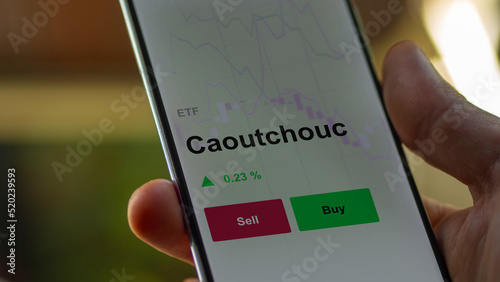 Un investisseur analyse un fonds etf caoutchouc sur un graphique. Un téléphone affiche le cours de l'ETF. Texte en français francais Caoutchouc