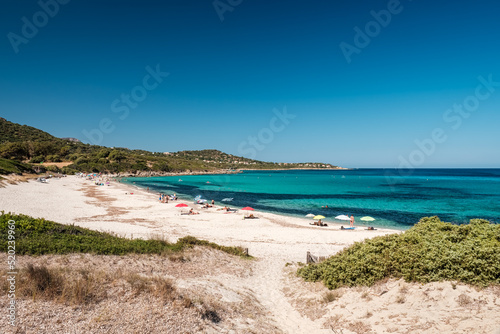 Fototapeta Naklejka Na Ścianę i Meble -  Holidaymakers enjoy the turquoise Mediterranean sea at Bodri beach in the Balagne region of Corsica