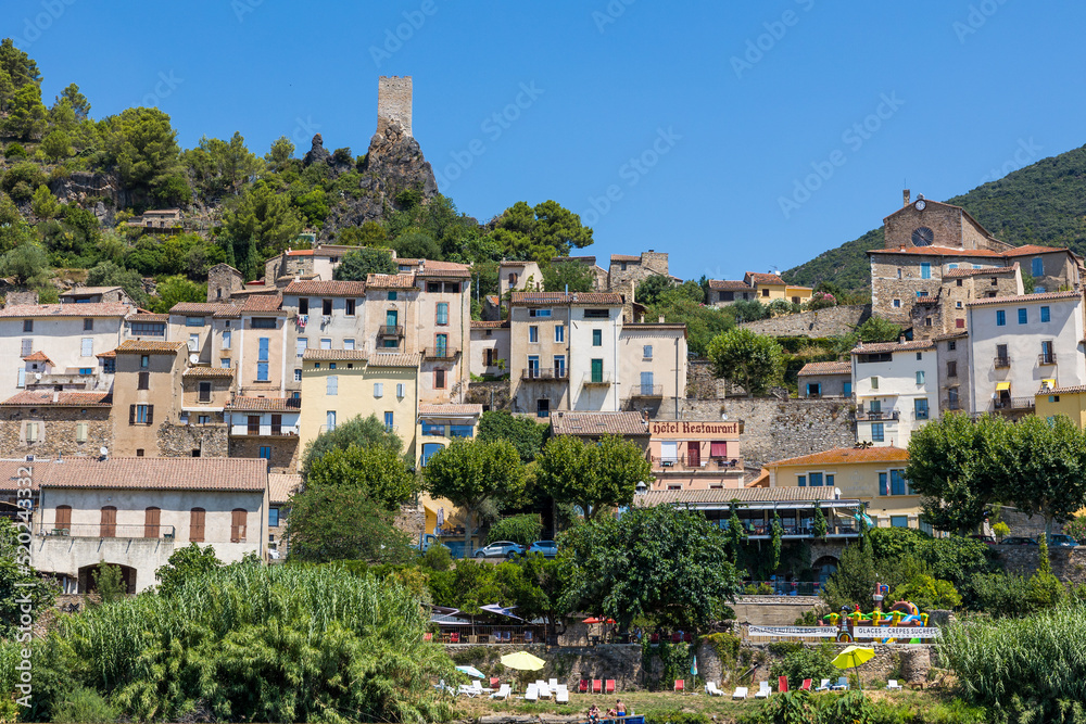 Vue estivale sur le village de Roquebrun depuis les berges de l'Orb