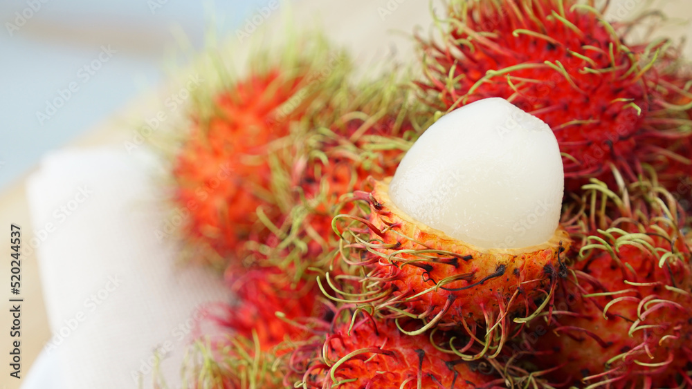 Rambutan peeled. Fresh and ripe rambutan sweet tropical fruit. Full frame shoot of bunch of red rambutan fruits. Close-up of peeled rambutan. The sweet fruit is a round to oval single-seeded berry. Rambutan peeled. Fresh and ripe rambutan sweet tropical fruit. Full frame shoot of bunch of red rambutan fruits. Close-up of peeled rambutan. The sweet fruit is a round to oval single-seeded berry.