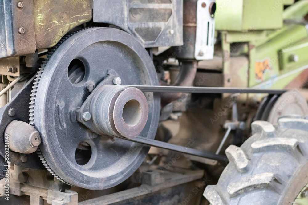 Typical heavy diesel walking tractor with trailer. Agricultural transport equipment of the countryside. Portable agricultural equipment, walking minitractor. The start system is mechanical and manual. Typical heavy diesel walking tractor with trailer. Agricultural transport equipment of the countryside. Portable agricultural equipment, walking minitractor. The start system is mechanical and manual.