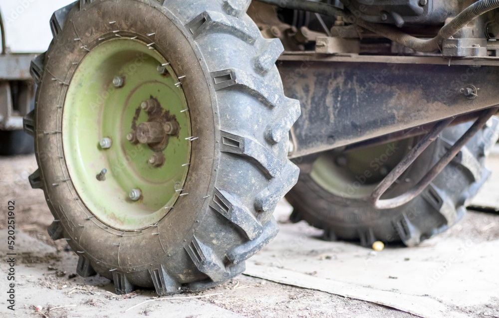 Typical heavy diesel walking tractor with trailer. Agricultural transport equipment of the countryside. Portable agricultural equipment, walking minitractor. The start system is mechanical and manual.