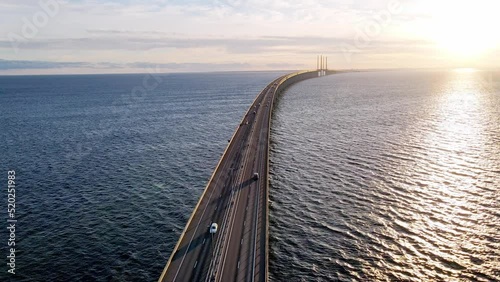 Drone flying over an Oresund bridge at the sunset in summer. Cinematic shot of long tunnel bridge between Sweden and Denmark. Oresund bridge from the top. High quality 4k footage photo