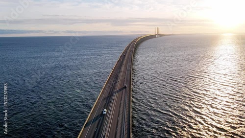 Drone flying over an Oresund bridge at the sunset in summer. Cinematic shot of long tunnel bridge between Sweden and Denmark. Oresund bridge from the top. High quality 4k footage