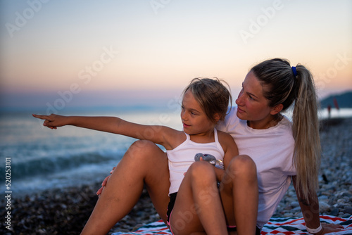 Happy family at the beach. Mother and daughter enjoying in sunset.  © DusanJelicic