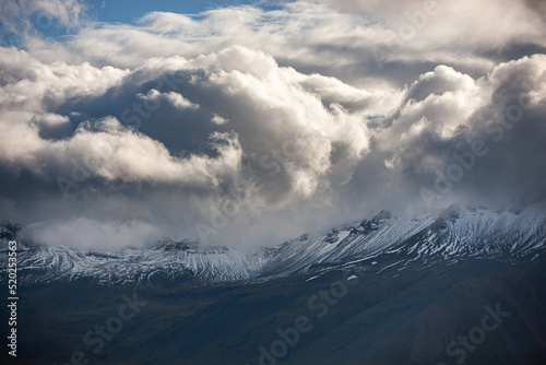 View of snowy mountains and thick clouds