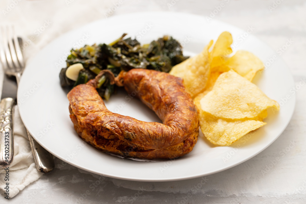 fried typical portuguese smoked sausage with chips and spinach