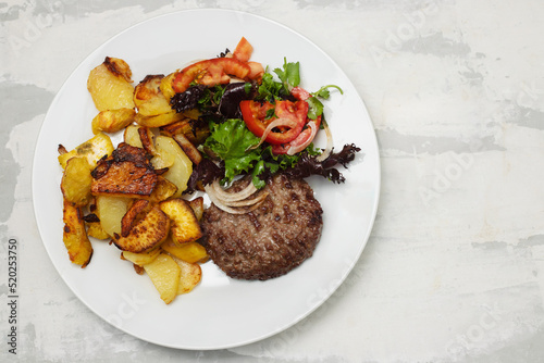 fresh grilled hamburgers with potato and salad in small bowl
