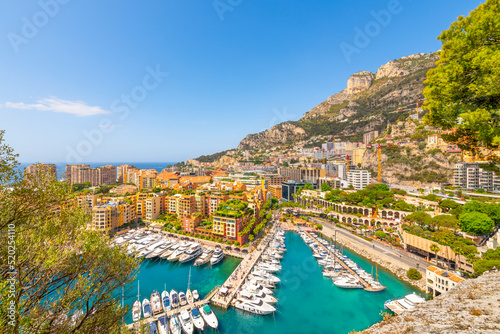 View of the Fontvieille Harbor Port with luxury yachts and sailboats in the turquoise waters of the marina in view along the Mediterranean Sea and French Riviera.