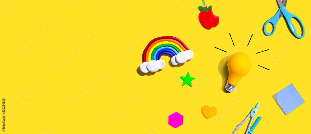 Idea light bulb with a rainbow and school supplies overhead view - flat lay Idea light bulb with a rainbow and school supplies overhead view - flat lay