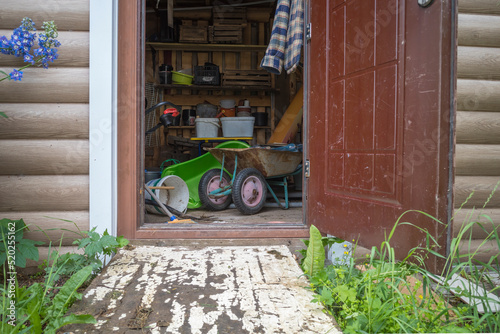 a shed with an open door in which there is a household garden equipment