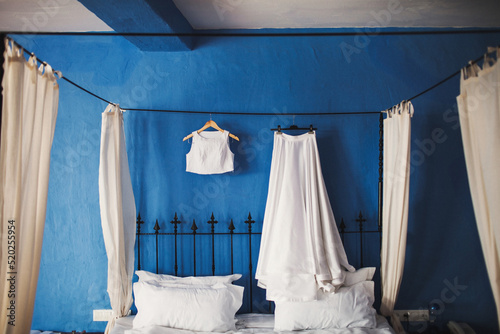 Wedding dress hanging on a blue background © tsezarina