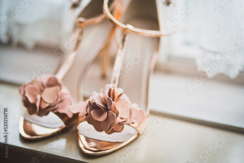 Pink wedding shoes on a wooden windowsill