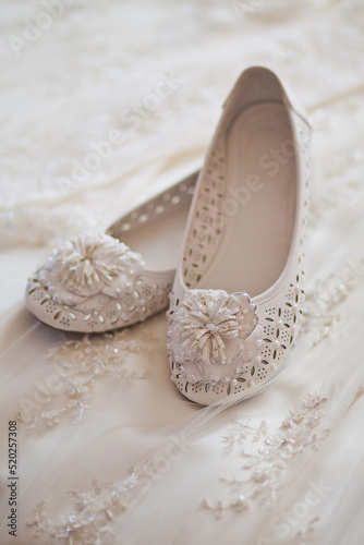 White shoes lie on a wedding dress