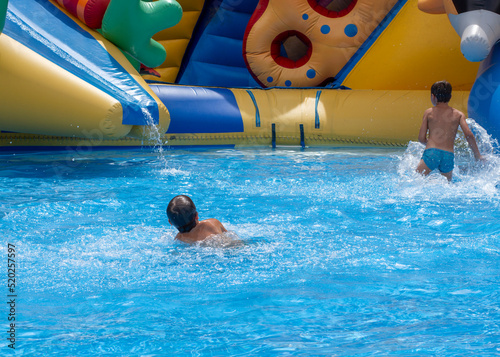 Children play and swim in pool. Two children are having fun in pool. Friends splashing in pool having fun leisure time. Summer vacation concept. Cute children playing in swimming pool