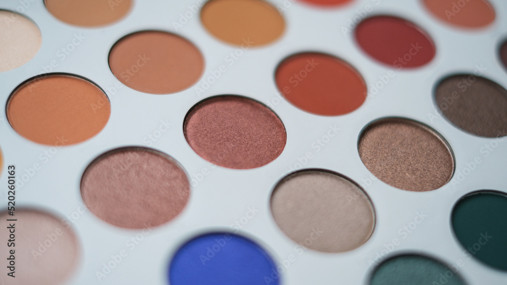 Selective focus of eyeshadow palette with various colors in pearly and matte closeup
