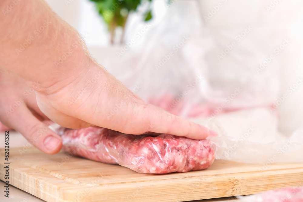 A man makes flat minced pork and beef in bags for storage in the freezer.