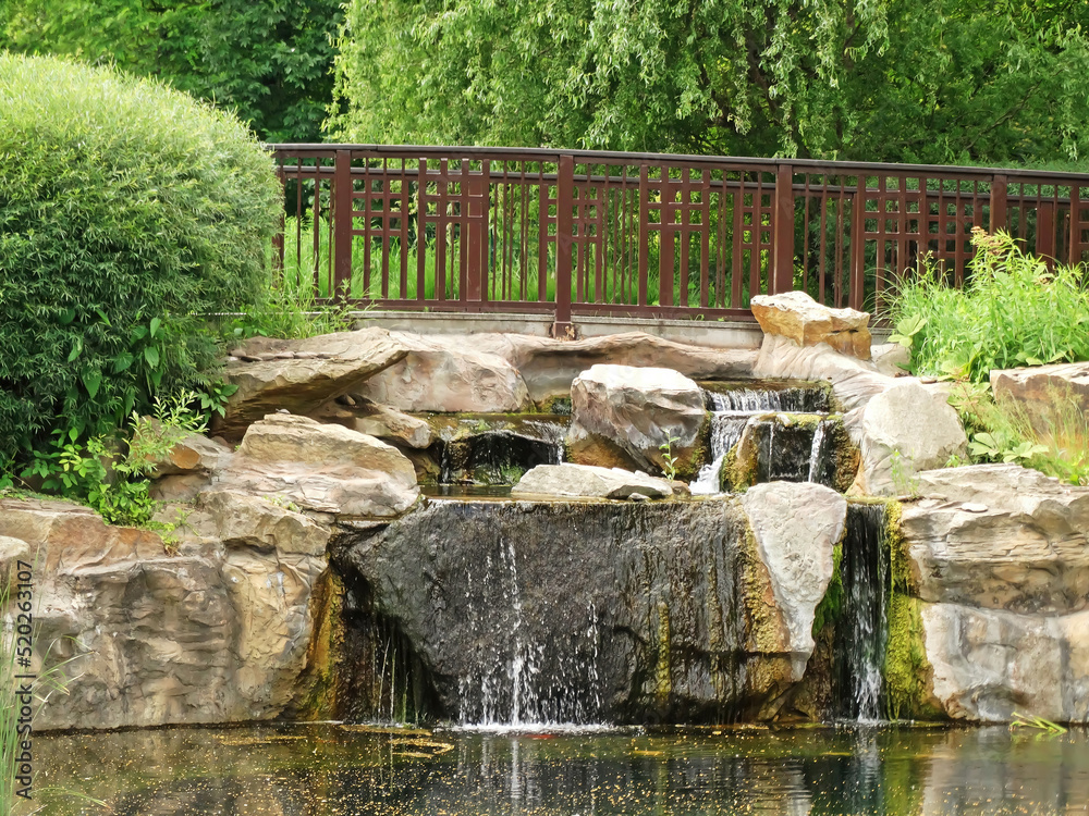 A small decorative waterfall in the garden. Landscape design