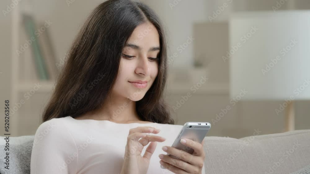 Close up carefree joyful girlfriend lady relaxing at home apartment typing sms message on mobile phone chatting use cell wireless connection for online communication scrolling images in social network Close up carefree joyful girlfriend lady relaxing at home apartment typing sms message on mobile phone chatting use cell wireless connection for online communication scrolling images in social network