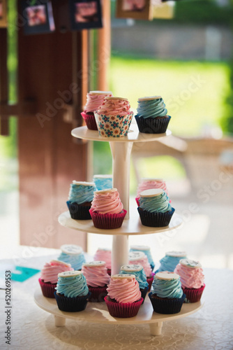 Muffins with pink cream and signs on a tray