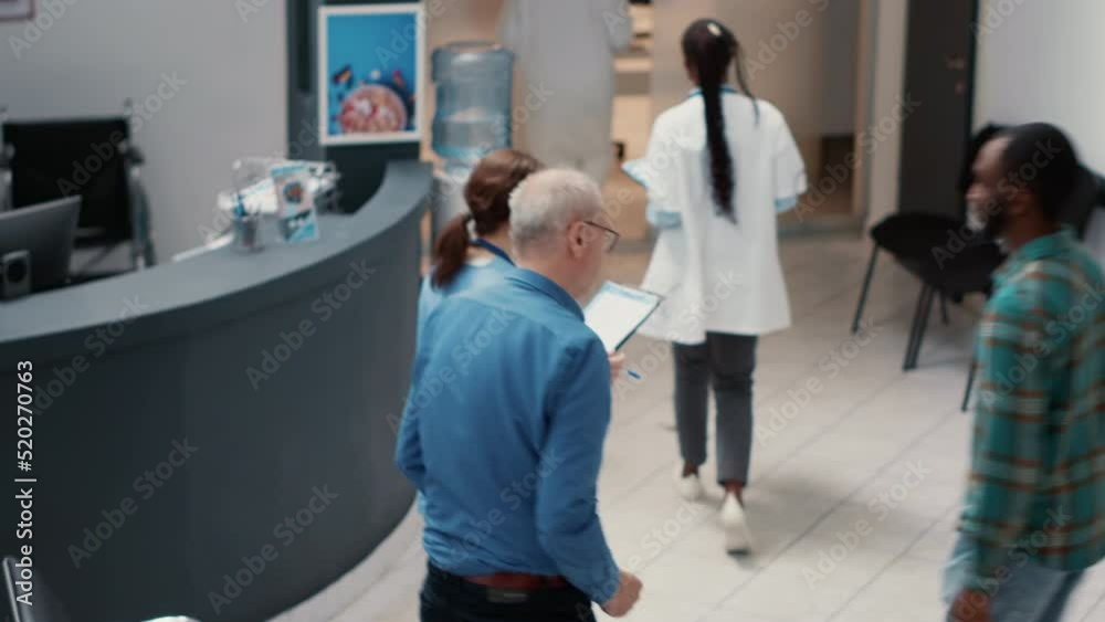 Impatient group of people asking to write healthcare report and waiting in busy hospital reception lobby. Being in medical clinic waiting area to attend consultation appointment. Handheld shot.