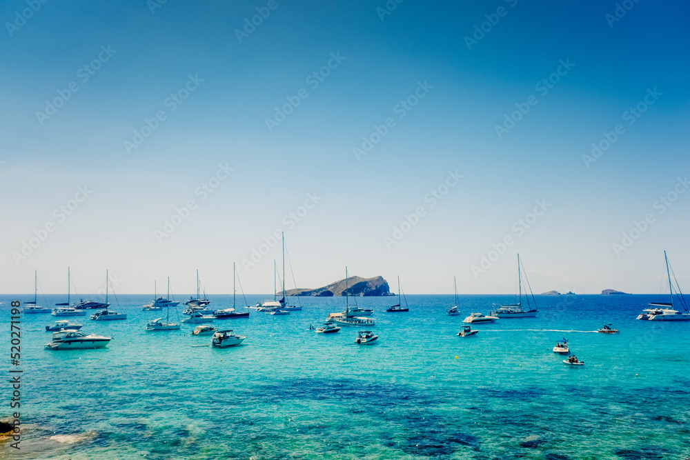 Ibiza, spain - July 28, 2022: Several pleasure boats anchored in a cove on the island of Ibiza to watch the sunset.