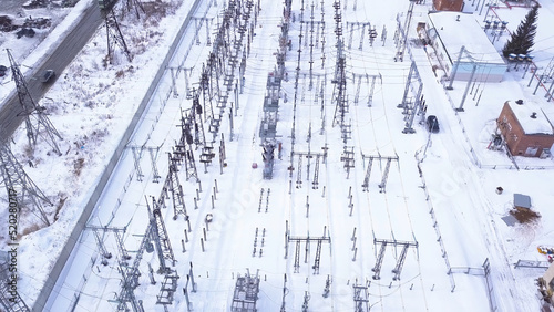 Rows of electric poles of substation. Action. Top view of small electrical substation with rows of transformers in suburbs. Suburban electric substation in winter © Media Whale Stock