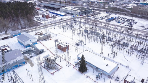 Top view of electric city substation. Action. Electrical substation with transformers distributing high voltage throughout city. Suburban electric substation in winter. Electric power industry