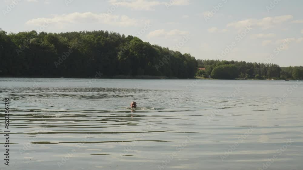 Shirtless Man Swims On The Lake Of Jezioro Glebokie In Poland. Static Shot Shirtless Man Swims On The Lake Of Jezioro Glebokie In Poland. Static Shot