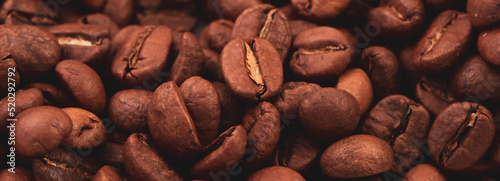 Coffee lover view of roasted coffee beans for background and texture. Dumped roasted coffee beans can be used as background and texture. Photo banner. roasted coffee