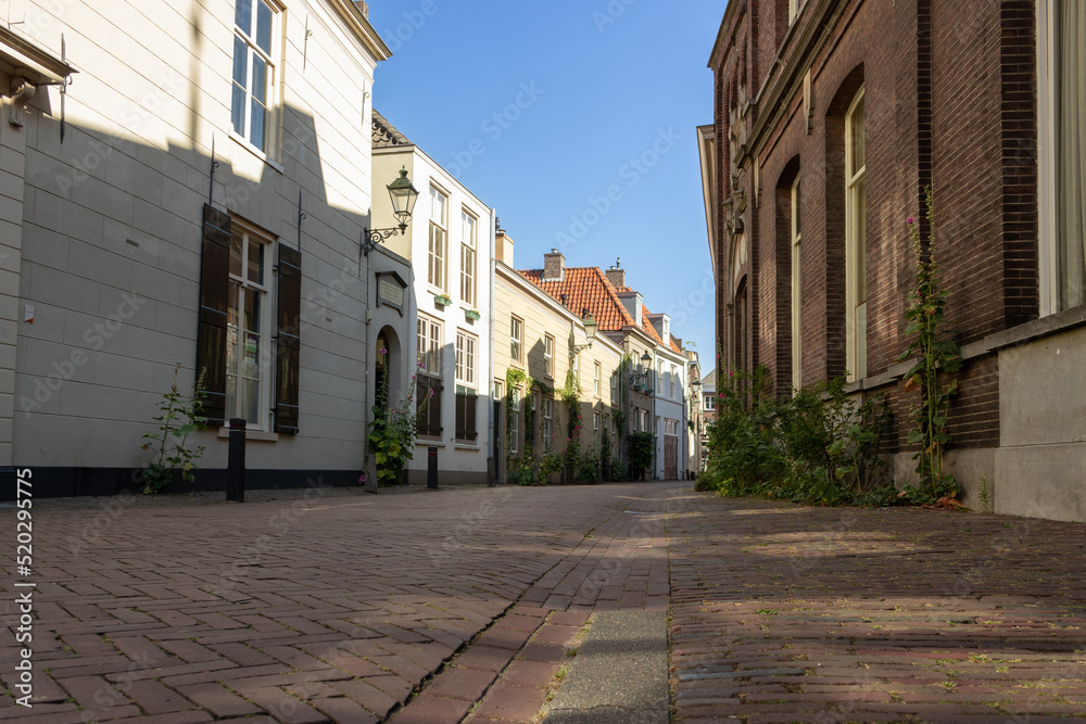 Clarastreet in the direction of the Hinthamerstraat. The sun is shining on a part of the left buildings. Den Bosch, North Brabant, the Netherlands - July 30 2022.
