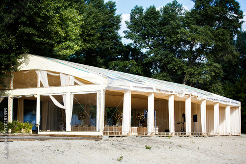 Spacious tent on the sand for a wedding party