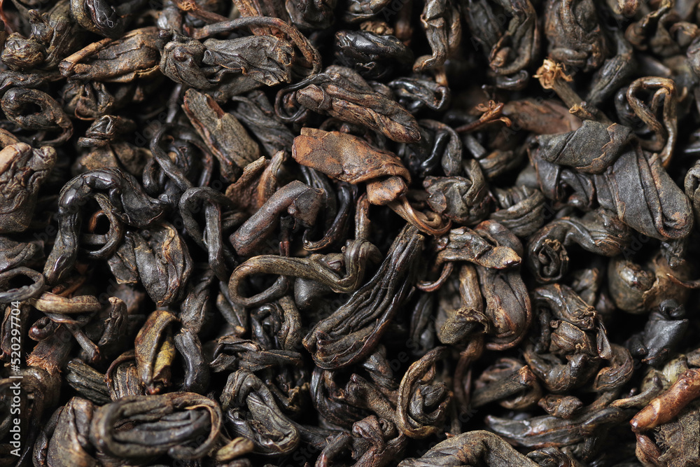 Premium black loose leaf tea as a background. Texture of dry black tea leaves. Extreme macro mode Premium black loose leaf tea as a background. Texture of dry black tea leaves. Extreme macro mode