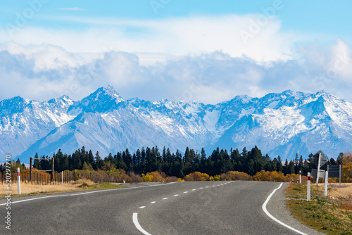 Road winding towards snowy mountain range, South Island, New Zealand photo